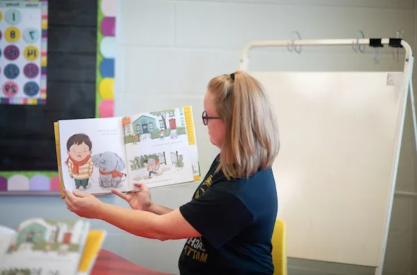 Elementary teacher reading books to students